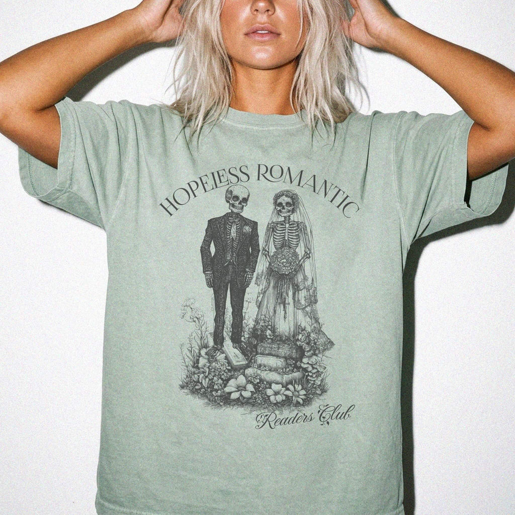 Hopeless Romantic Readers Club Tee in Bay – vintage-style Comfort Colors graphic tee for dark romance readers. Graphic features a skeleton couple on their wedding day.