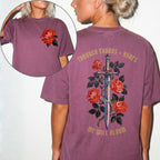 Comfort Colors 1717 Berry relaxed fit tee with painterly red rose pocket print on front and ornate sword wrapped in roses with red gothic text 'Through Thorns + Ashes We Will Bloom' on back