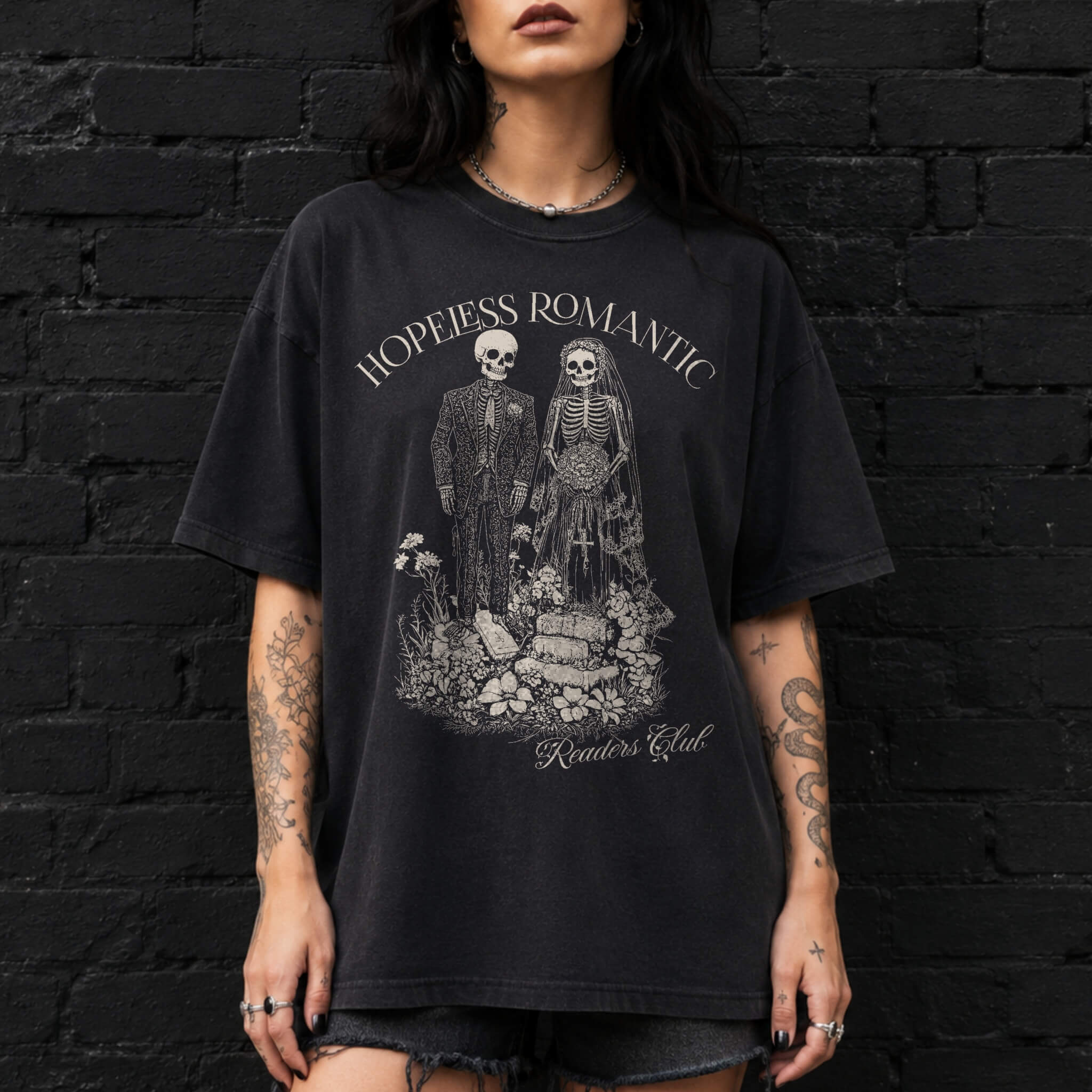 Hopeless Romantic Readers Club Tee in Black – vintage-style Comfort Colors graphic tee for dark romance readers. Graphic features a skeleton couple on their wedding day.
