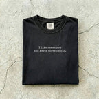 Black Comfort Colors tee folded flat reading "I like romantasy and maybe three people." in a typewriter font.