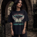 Woman wearing black Comfort Colors relaxed tee with Late Night Reader Society vintage metal graphic — winged open book and dagger design