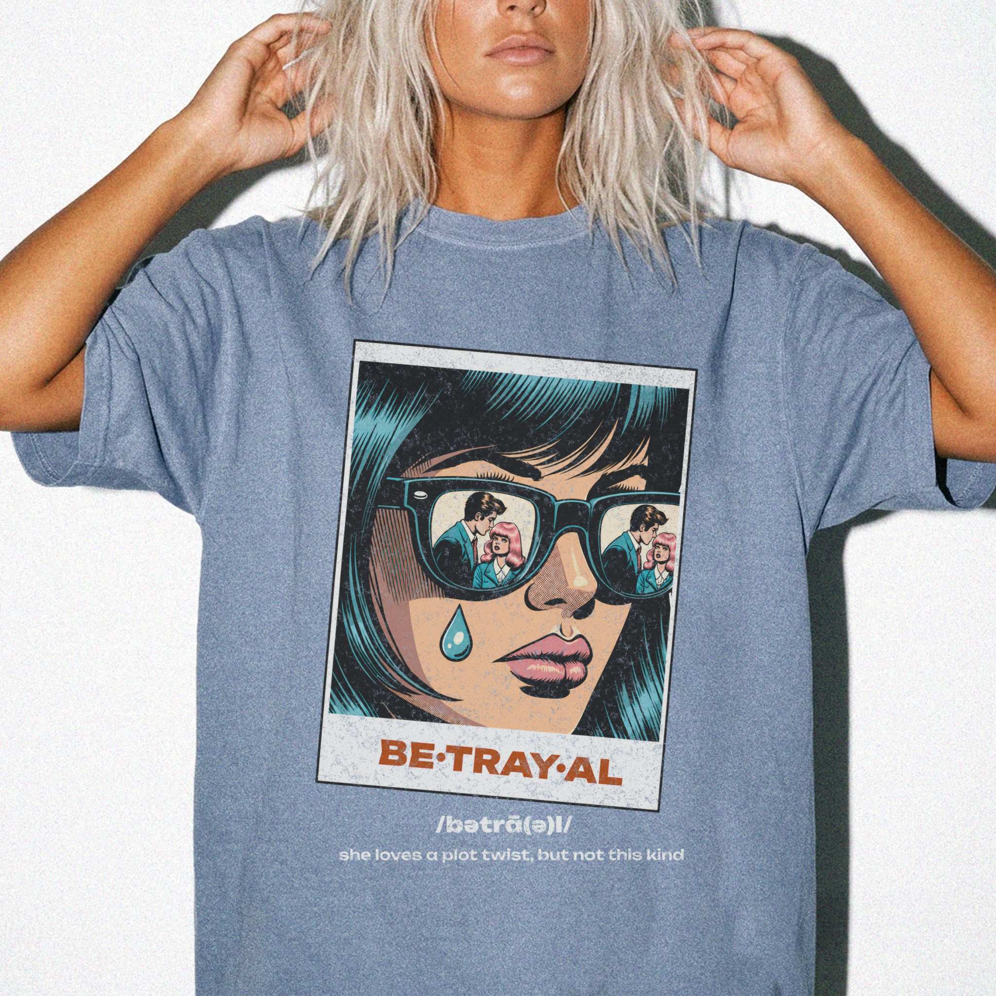 Blue Jean color Comfort Colors 1717 relaxed fit t-shirt with retro pop art graphic — a woman with teal hair and sunglasses reflecting a couple, a single tear on her cheek, with the word BE·TRAY·AL (betrayal) and the tagline "she loves a plot twist, but not this kind" 