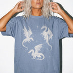 Blue Jean color Comfort Colors 1717 relaxed fit t-shirt with whimsigoth fantasy graphic — three detailed dragon illustrations surrounded by stars and celestial details in off-white line art