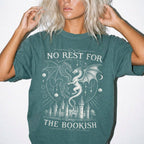 Blue Spruce Comfort Colors 1717 relaxed fit t-shirt with gothic romantasy graphic — two dragons soaring over a castle beneath moons and celestial details, with the text "No Rest for the Bookish"