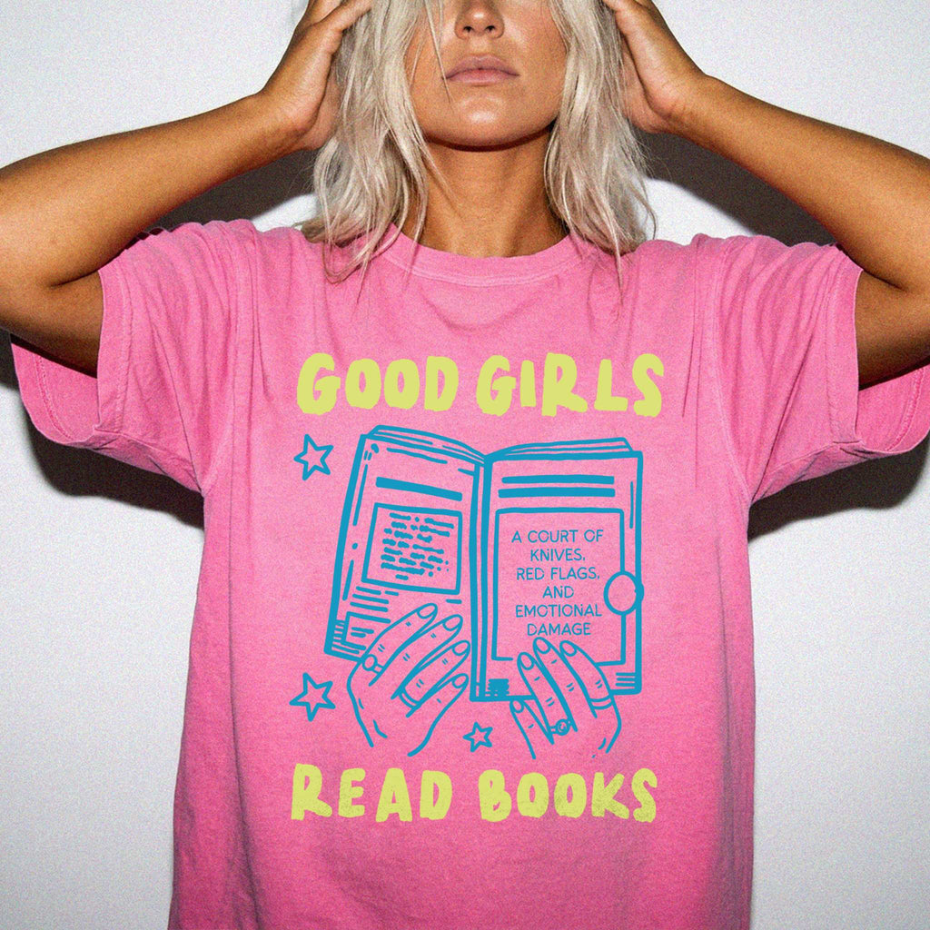 Crunchberry color Comfort Colors 1717 relaxed fit t-shirt with Y2K retro doodle graphic — hands holding an open book titled "A Court of Knives, Red Flags, and Emotional Damage" with a blue book illustration and the text "Good Girls Read Books" above and below