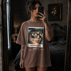 Espresso Comfort Colors 1717 relaxed fit t-shirt with retro pop art graphic — a woman with teal hair and sunglasses reflecting a couple, a single tear on her cheek, with the word BE·TRAY·AL (betrayal) and the tagline "she loves a plot twist, but not this kind" 