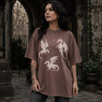 Espresso color Comfort Colors 1717 relaxed fit t-shirt with whimsigoth fantasy graphic — three detailed dragon illustrations surrounded by stars and celestial details in off-white line art