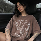 Woman wearing an espresso color relaxed fit Comfort Colors tee with a vintage graphic of a woman warrior dragon rider and "We Ride at Dawn" text.