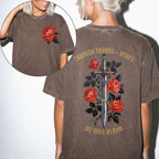Comfort Colors 1717 Espresso relaxed fit tee with painterly red rose pocket print on front and ornate sword wrapped in roses with gold gothic text 'Through Thorns + Ashes We Will Bloom' on back