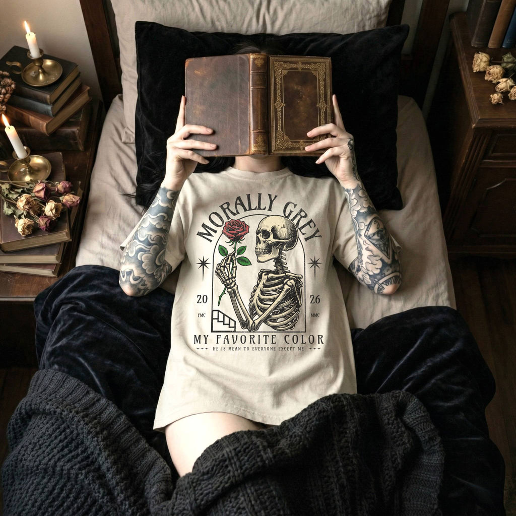 Ivory Comfort Colors 1717 relaxed fit t-shirt with dark romance graphic — a skeleton holding a red rose beneath an arch with the text "Morally Grey — My Favorite Color" and the tagline "He is mean to everyone except me"