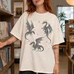 Ivory color Comfort Colors 1717 relaxed fit t-shirt with whimsigoth fantasy graphic — three detailed dragon illustrations surrounded by stars and celestial details in dark grey line art