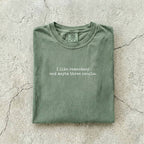 Moss Comfort Colors tee folded flat reading "I like romantasy and maybe three people." in a typewriter font.