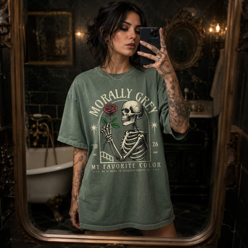 Moss color Comfort Colors 1717 relaxed fit t-shirt with dark romance graphic — a skeleton holding a red rose beneath an arch with the text "Morally Grey — My Favorite Color" and the tagline "He is mean to everyone except me"