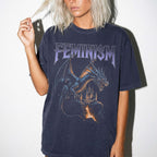 Woman wearing navy Comfort Colors relaxed tee with Feminism vintage metal graphic — dragon and lava-flowing castle design