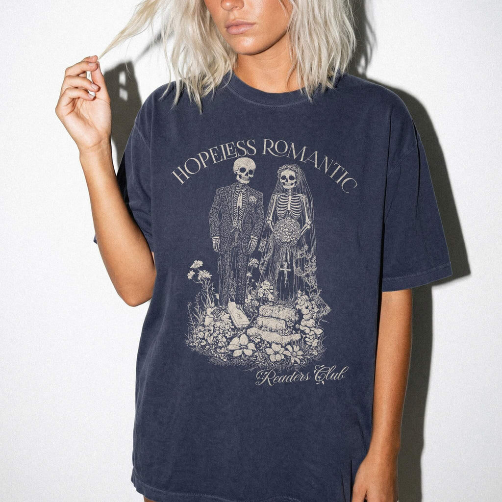 Hopeless Romantic Readers Club Tee in Navy – vintage-style Comfort Colors graphic tee for dark romance readers. Graphic features a skeleton couple on their wedding day.