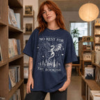 Navy color Comfort Colors 1717 relaxed fit t-shirt with gothic romantasy graphic — two dragons soaring over a castle beneath moons and celestial details, with the text "No Rest for the Bookish"