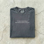 Pepper Comfort Colors tee folded flat reading "I like romantasy and maybe three people." in a typewriter font.