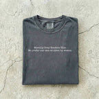 Pepper Comfort Colors tee folded flat on a concrete background reading "Morally grey readers club. We prefer our men written by women." in a minimal typewriter font.