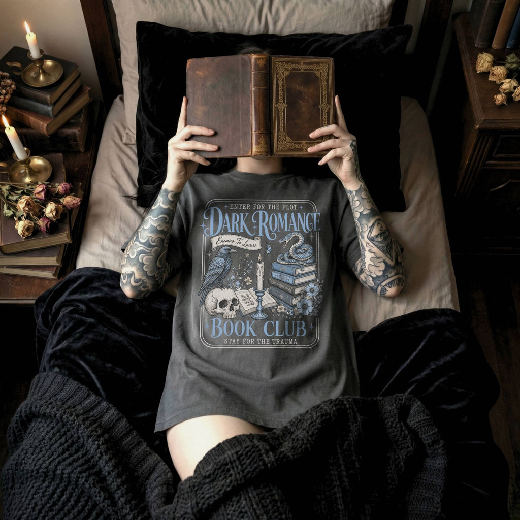 Pepper color Comfort Colors 1717 relaxed fit t-shirt with gothic dark romance graphic — a raven perched on a skull, a snake coiled on stacked books, a candle, and florals, with the text "Dark Romance Book Club — Enter for the Plot, Stay for the Trauma"