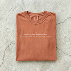 Yam Comfort Colors tee folded flat on a concrete background reading "Morally grey readers club. We prefer our men written by women." in a minimal typewriter font.